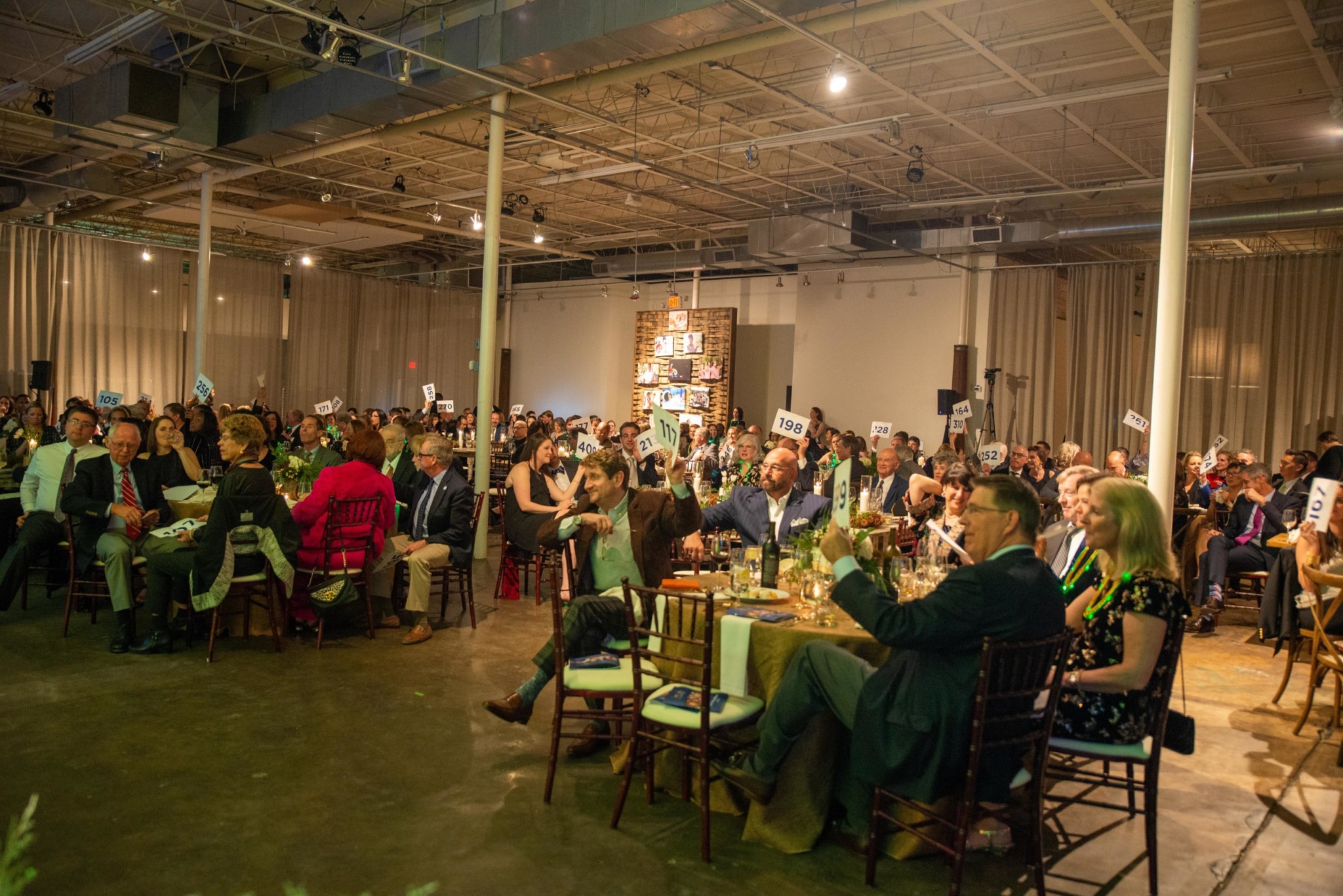 Event attendees participating in an auction at a Camp Kudzu event