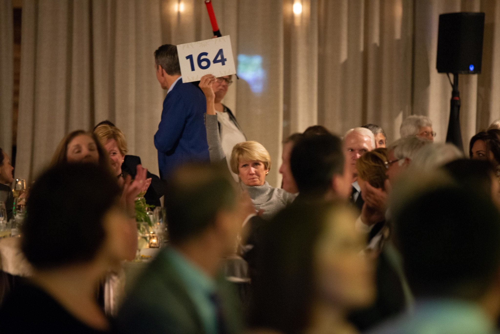 Event attendees participating in an auction at a Camp Kudzu event