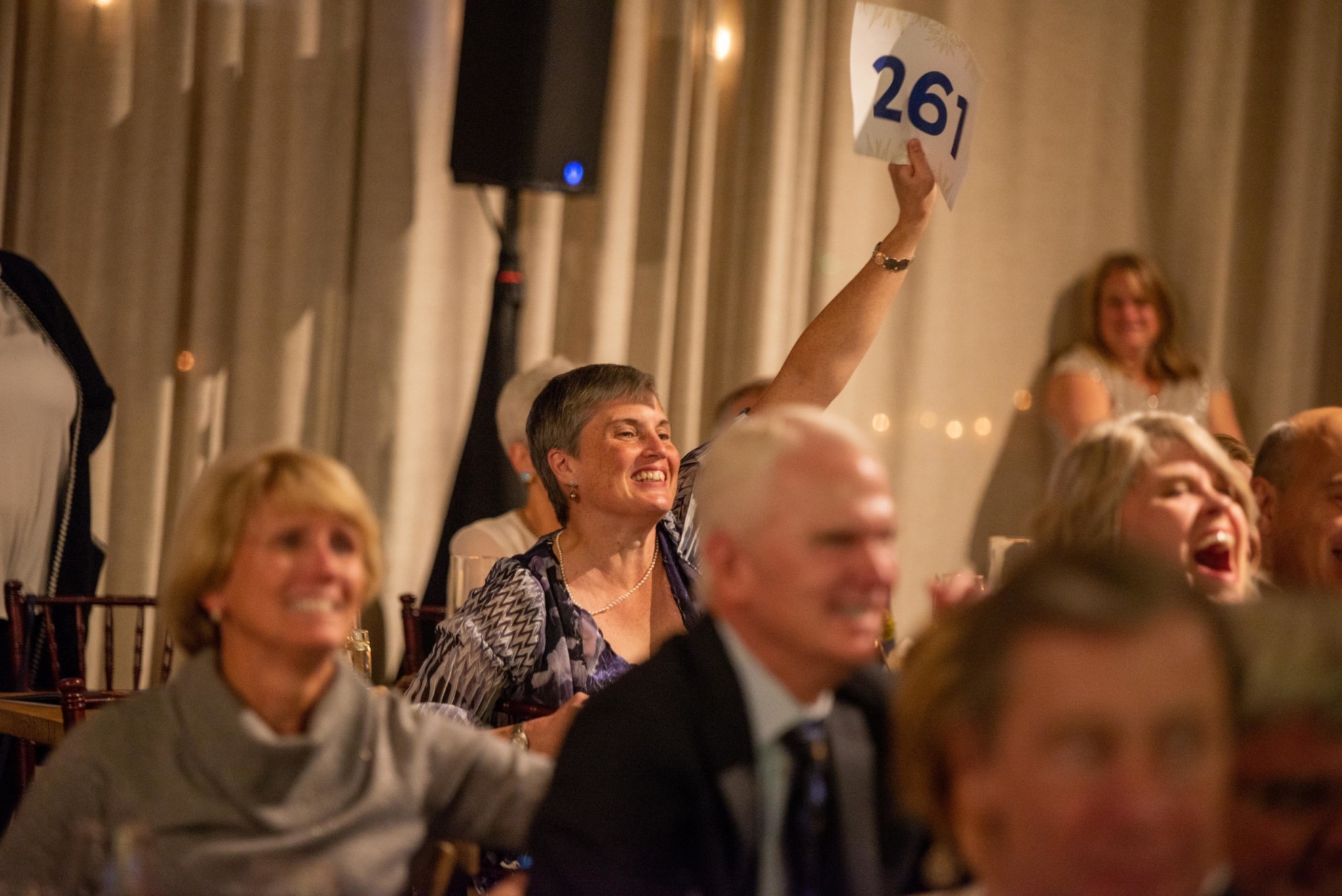 Event attendees participating in an auction at a Camp Kudzu event