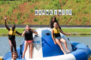 Children having fun on flotation device in a lake at Camp Barney