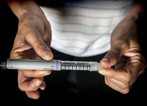A close-up of an insulin pen being held in someone's hands.